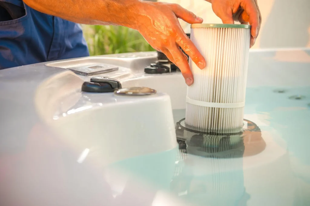 Person installing a new white pleated cartridge filter into a hot tub or cold plunge pool.