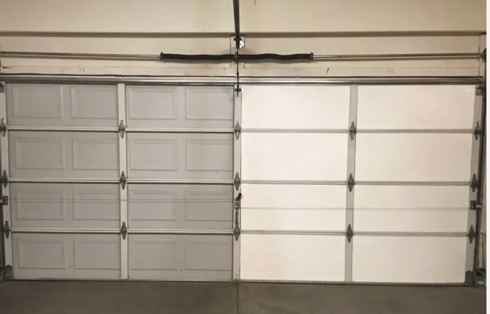 A comparative view of a two-car garage showing the visual difference between a standard uninsulated door panel and a bright white insulated garage door panel.